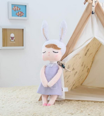 Peluche Metoo con un vestido morado.